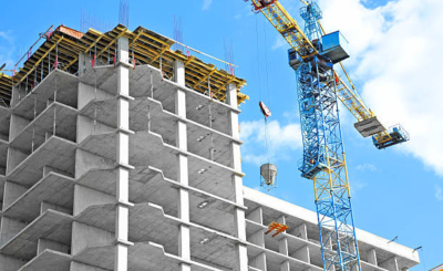 Crane and building under construction against blue sky